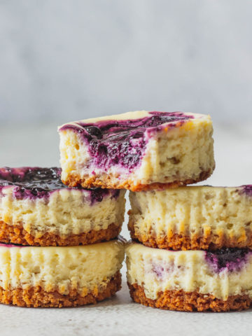 Mini Blueberry Cheesecakes Stacked on each other.