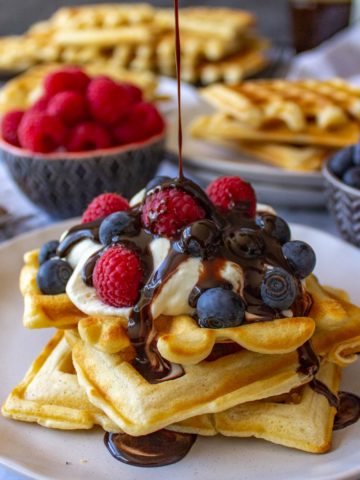 Super easy waffles with cream, berries and chocolate sauce.