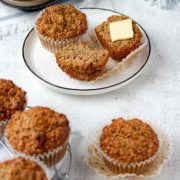 Bran muffins on a plate, sliced with a pat of butter.