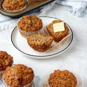Bran muffins on a plate, sliced with a pat of butter