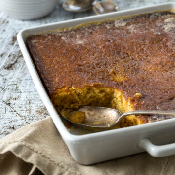 Malva pudding in a baking dish, with a portion cut out.