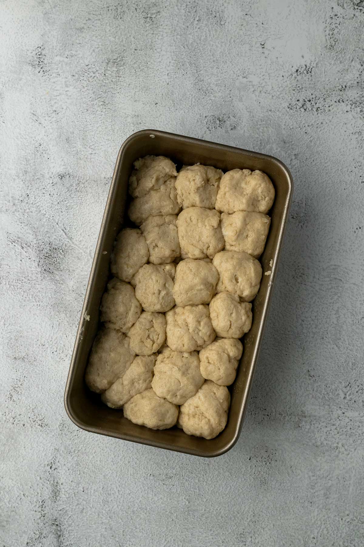 balls of rusk dough in a loaf tin