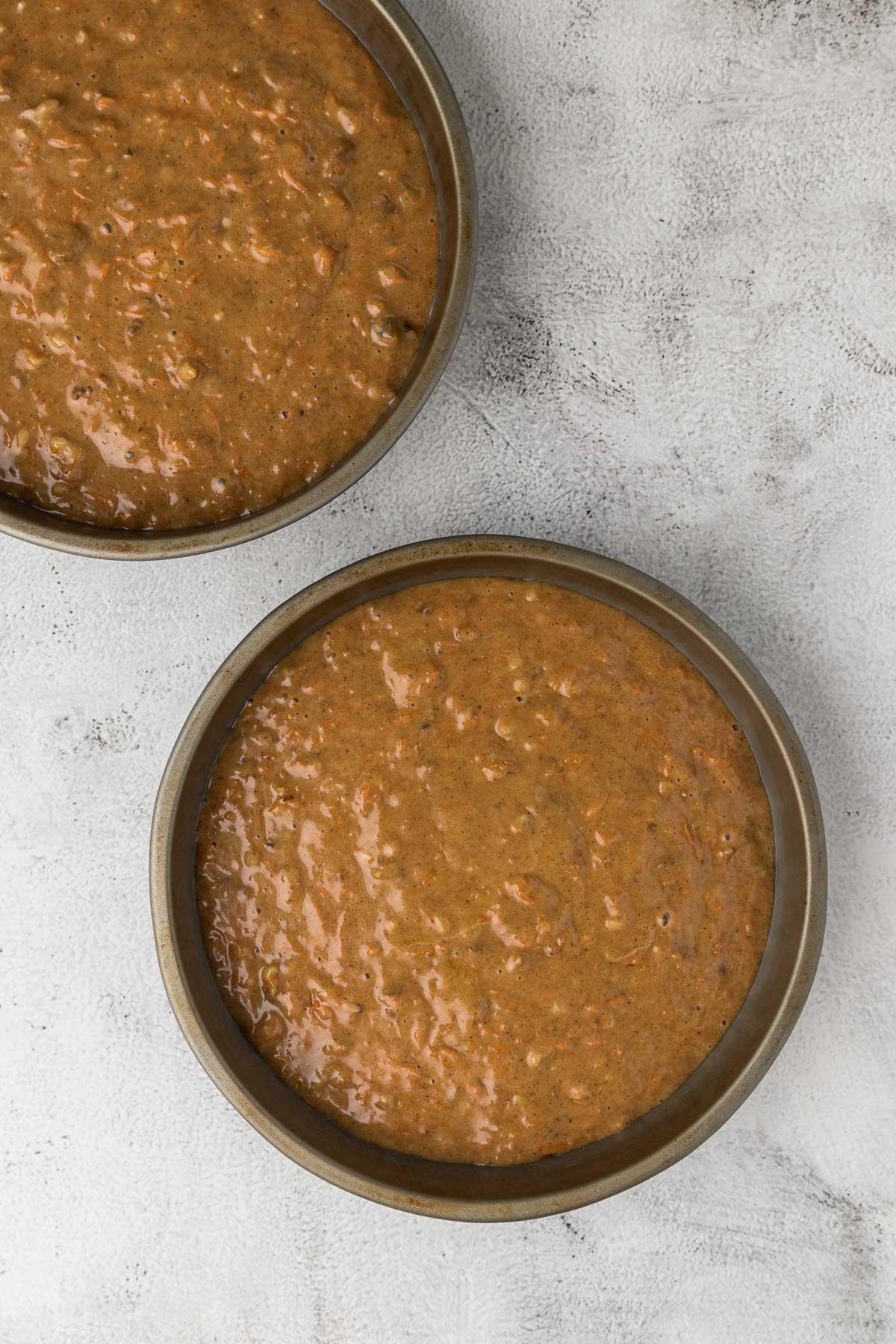 carrot cake batter divided between two cake pans