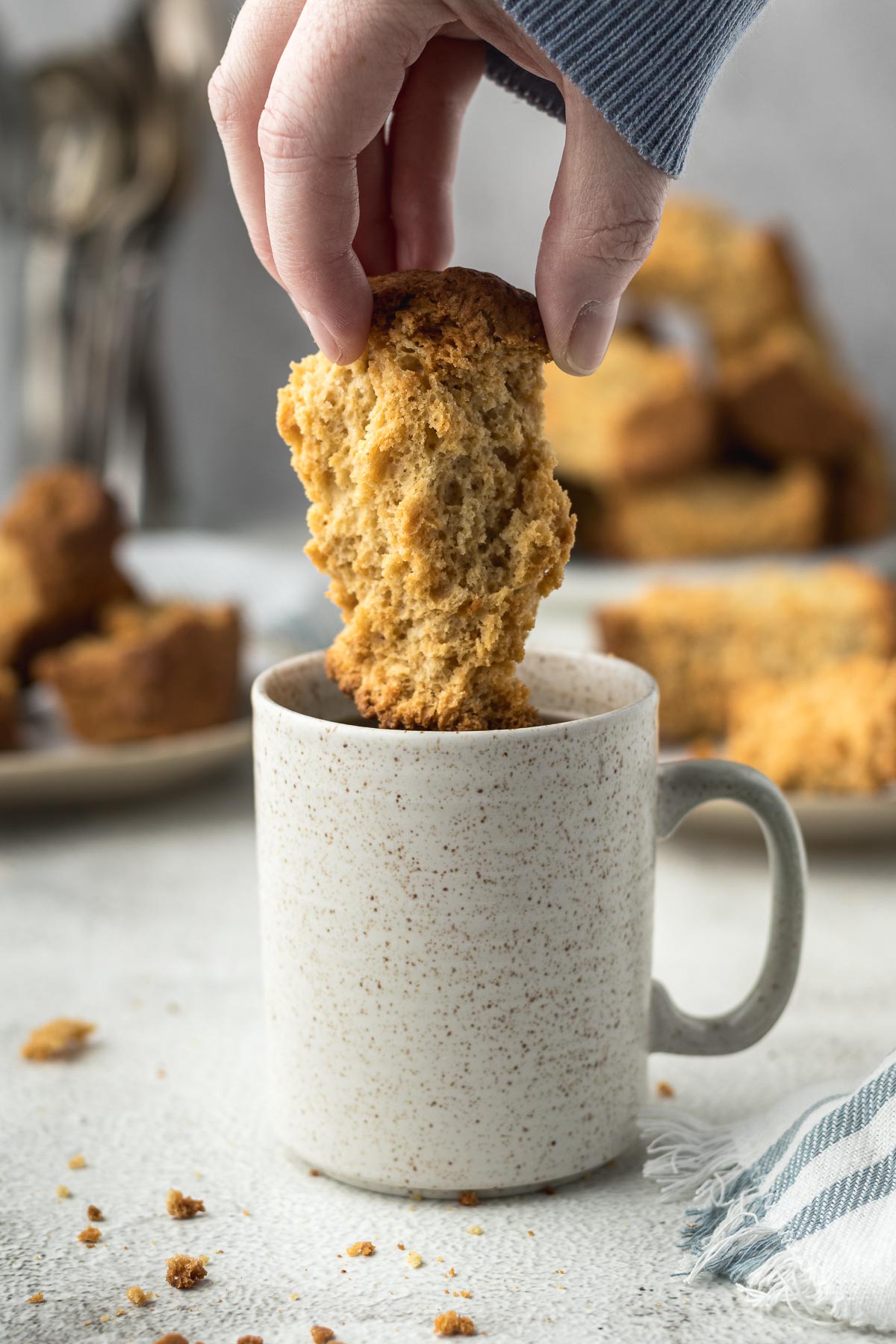 Buttermilk rusk being dunked into a cup of coffee.