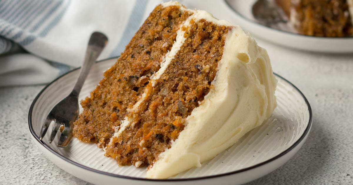 Slice of carrot cake showing cream cheese icing (frosting).