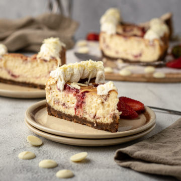 Slice of strawberry white chocolate cheese cake on a plate.