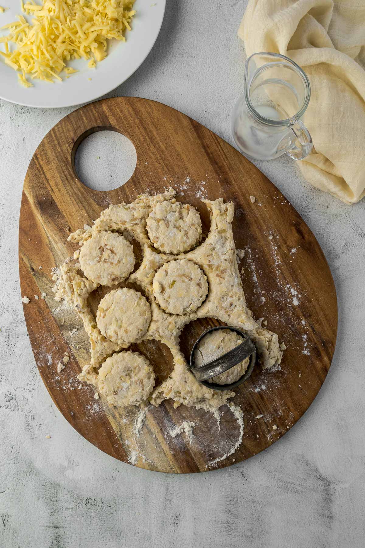 Scones cut out of dough on a board.