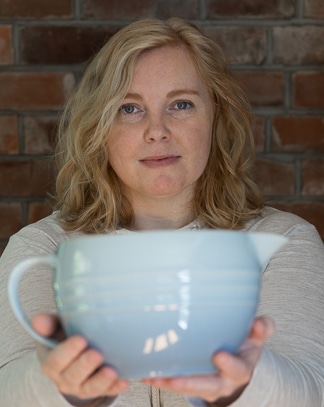 Woman holding a large mixing bowl.