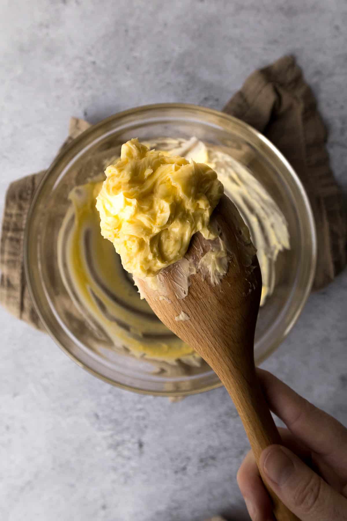 Partially creamed butter on a wooden spoon.