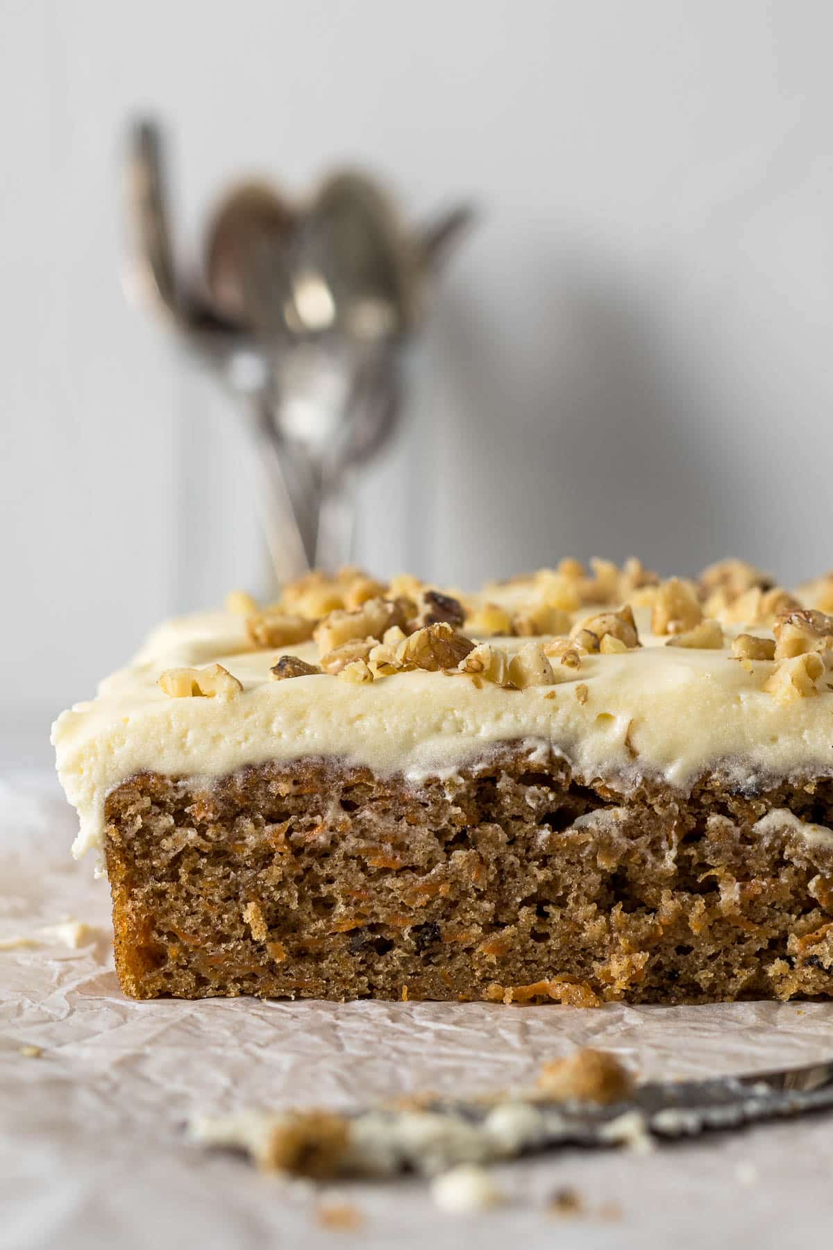 Sliced carrot cake tray bake with cream cheese frosting.