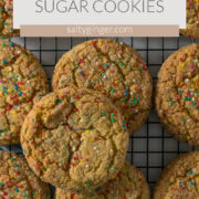 Sugar cookies with sprinkles on a cooling rack.