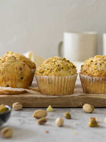 Pistachio muffins on a serving board.