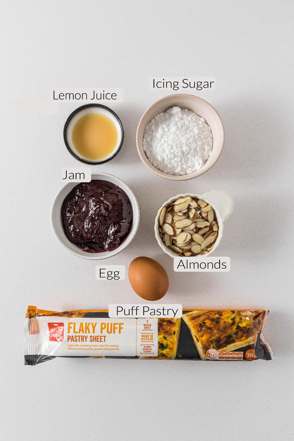 Jam puff pastry ingredients - lemon juice, icing sugar, jam, sliced almonds, egg, puff pastry.