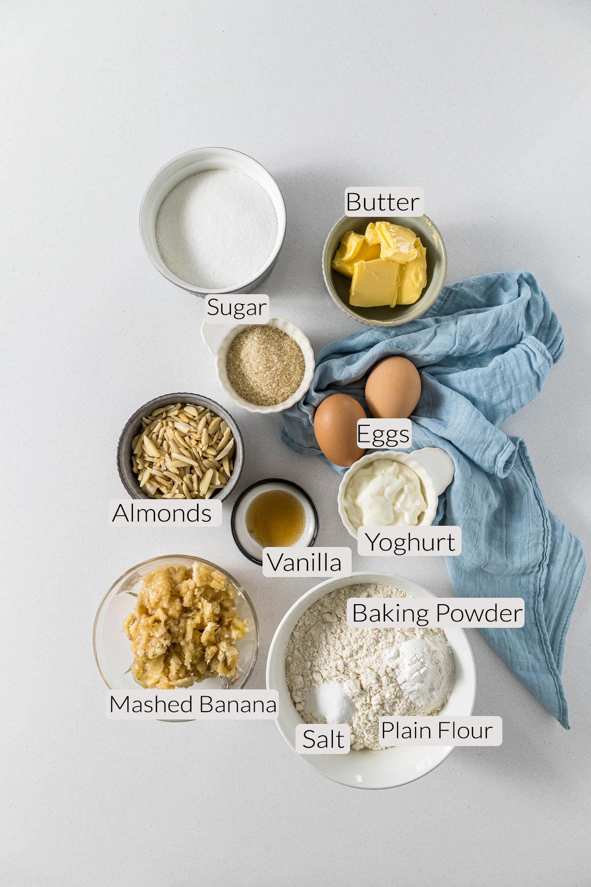 Banana bread ingredients - flour, salt, baking powder, bananas, almonds, sugar, butter, eggs and vanilla.