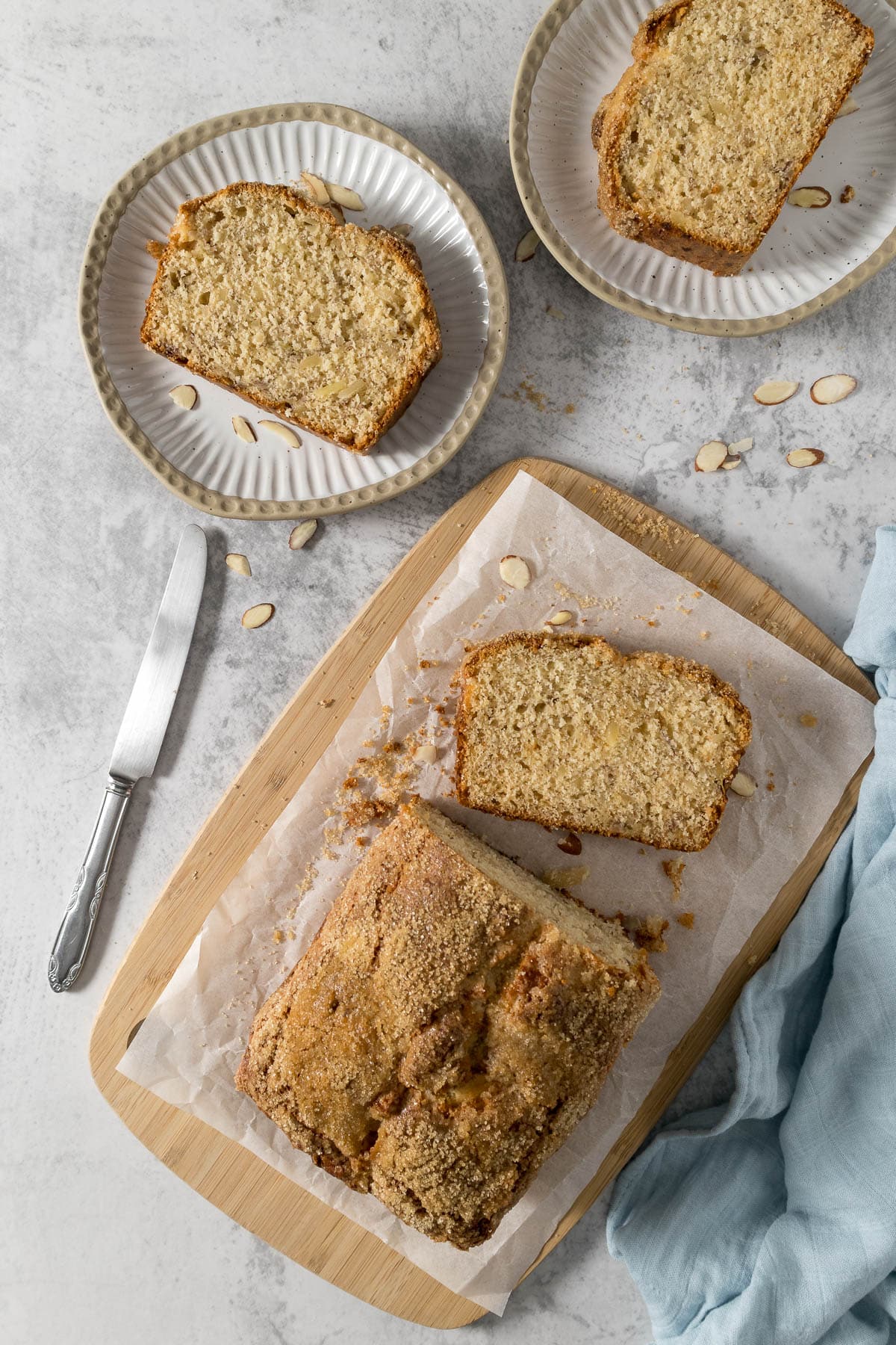Slice of banana bread with almonds on a plate.