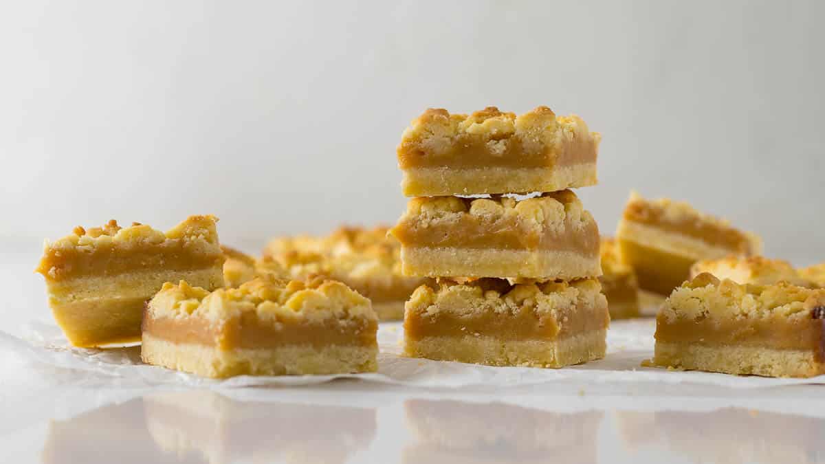 Three tan squares stacked on each other to show the shortbread and caramel layers.