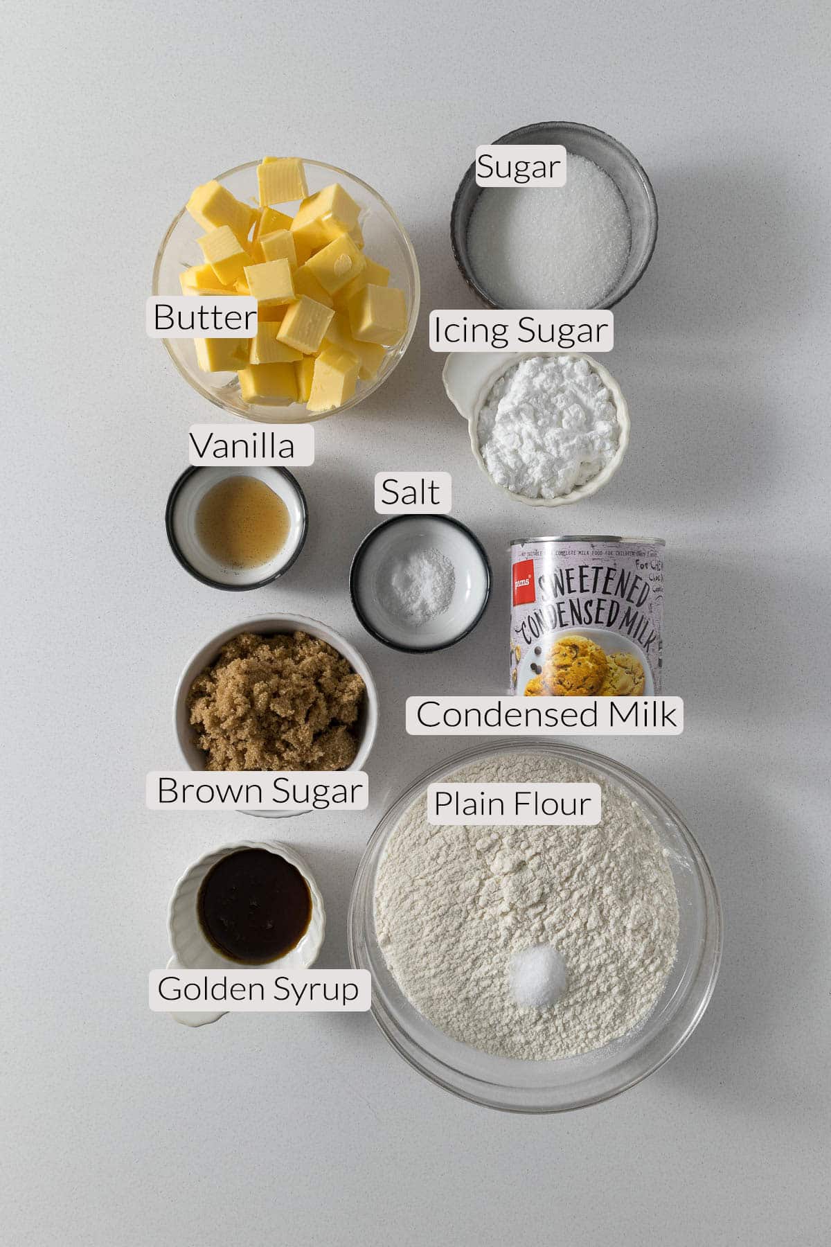 Tan slice ingredients - flour, salt, butter, sugar, vanilla, icing sugar, golden syrup, condensed milk.