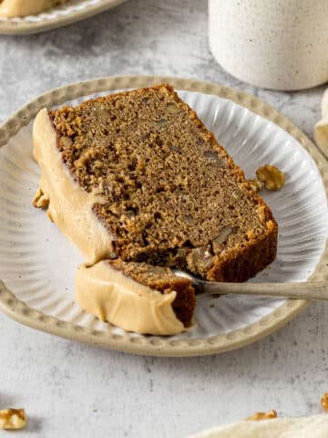 Slice of coffee and walnut loaf on a plate.