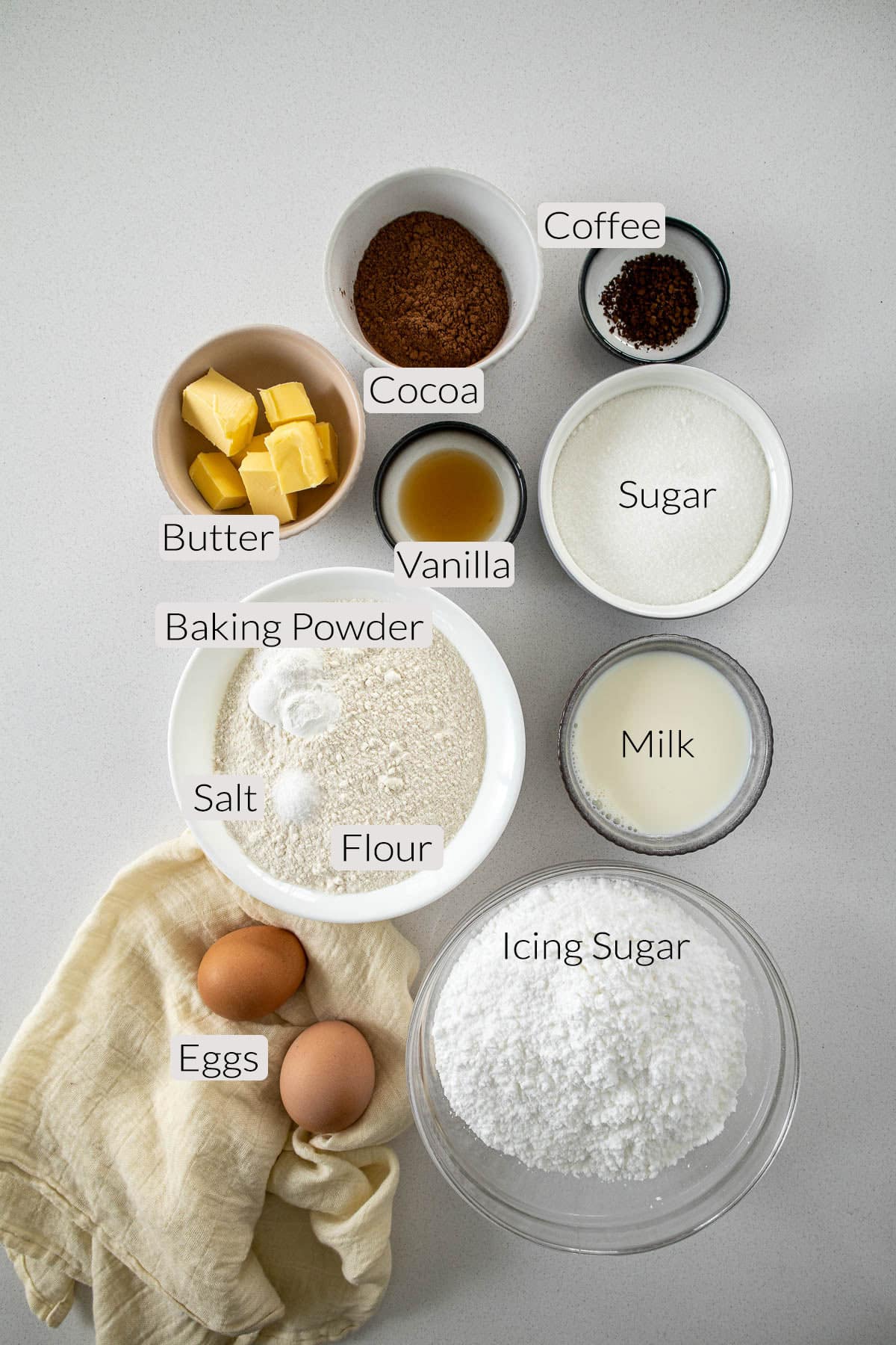 Chocolate Cupcakes Ingredients - butter, cocoa, coffee, vanilla, sugar, baking powder, salt, flour, milk, eggs, and icing sugar.