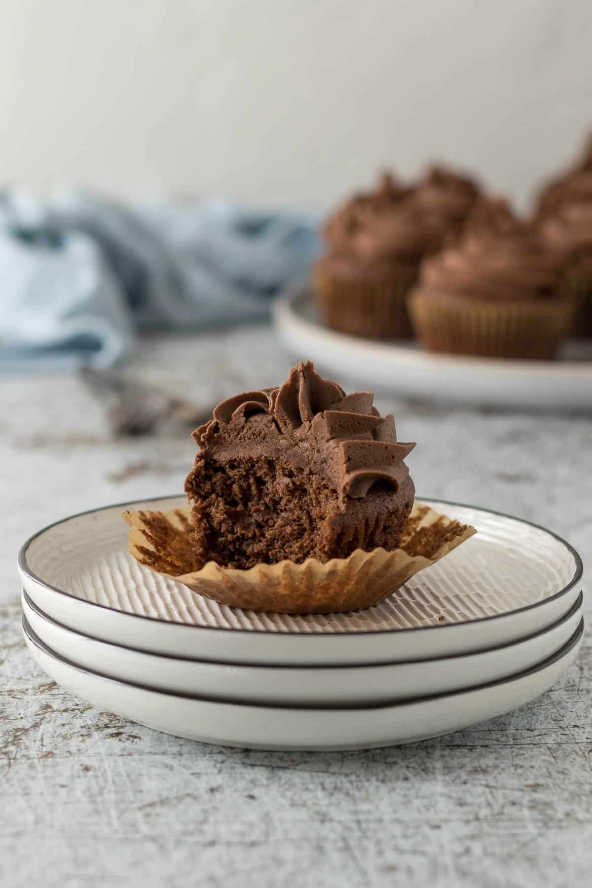 Chocolate cupcake with a bite out on a plate.