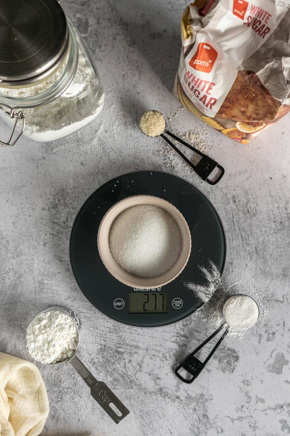 Sugar being weighed out on a kitchen scale.