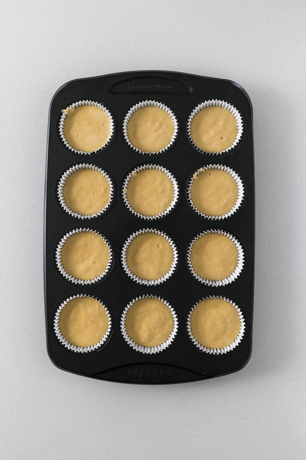 Step 6 - cupcake batter divided into 12 cupcake liners.