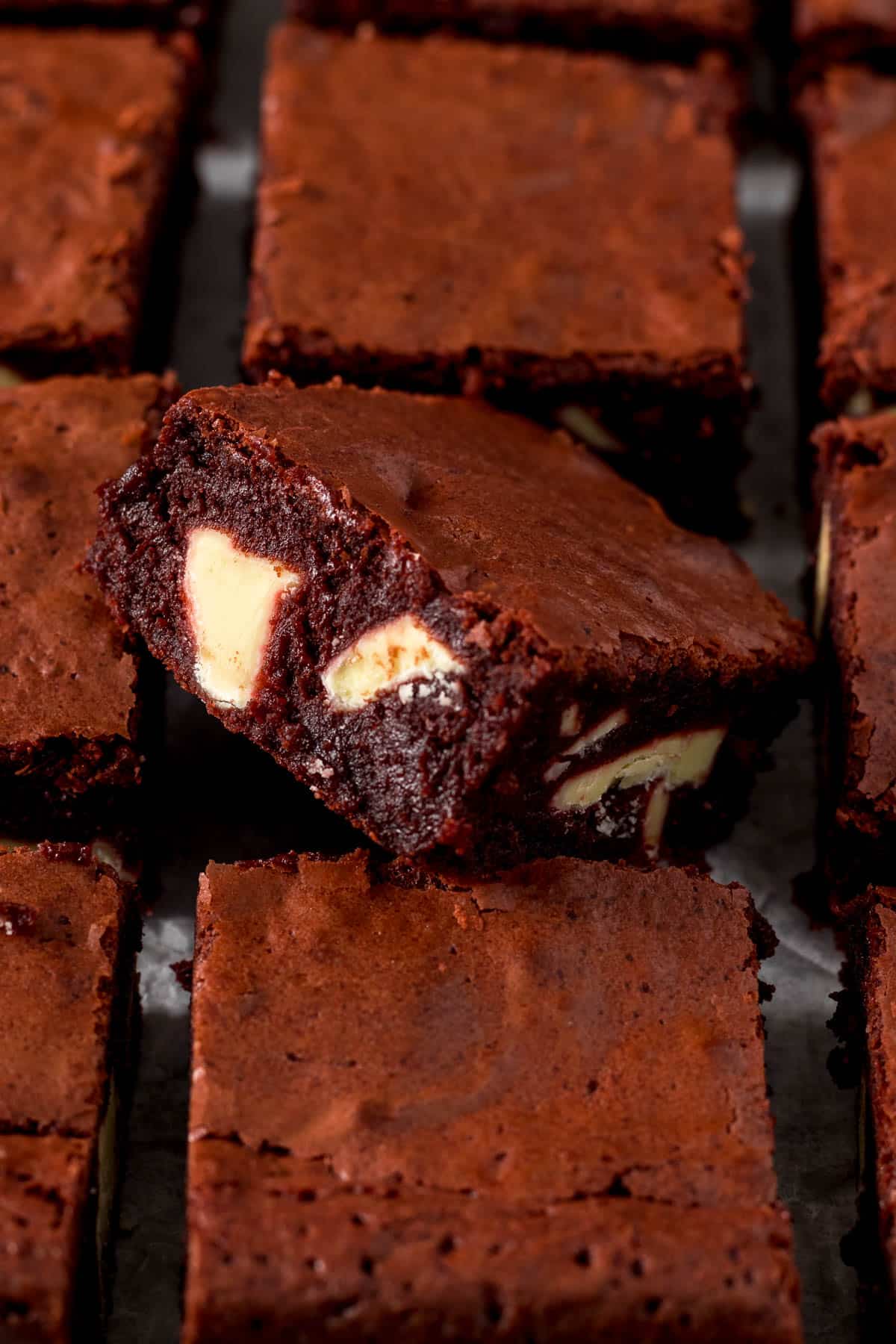 Close up of sliced red velvet brownie showing white chocolate chunks.