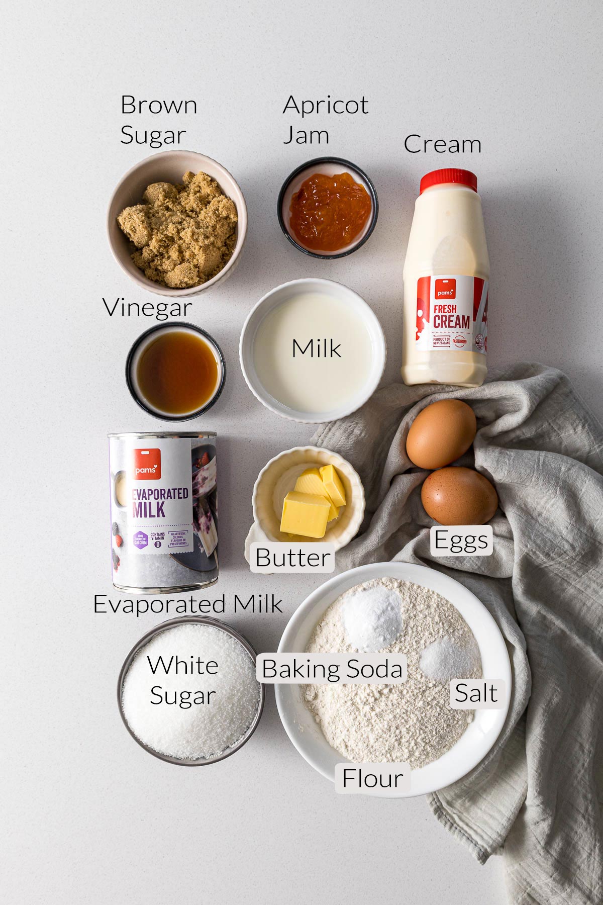 Malva pudding ingredients - sugar, cream, apricot jam, milk, eggs, butter, vinegar, flour, baking soda, salt and evaporated milk.