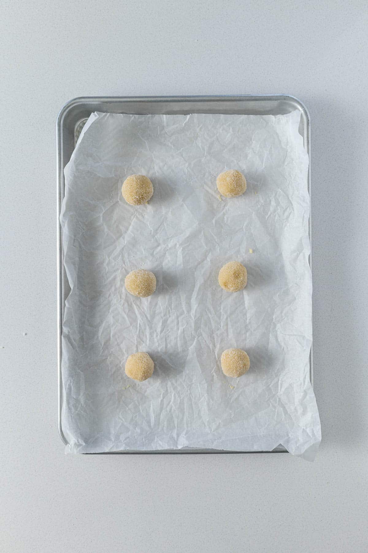 Step 6 - Cookie dough rolled in sugar and placed on a baking sheet ready for baking.