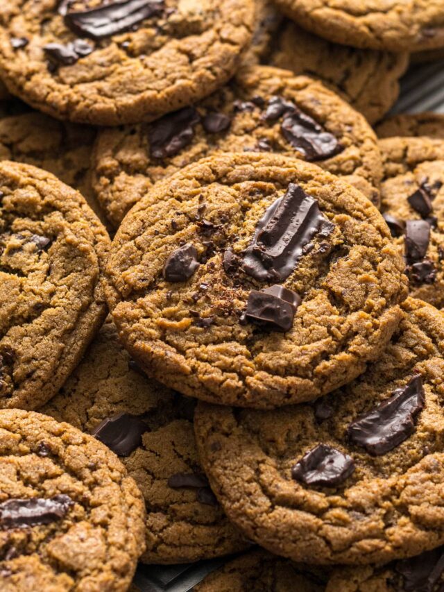 Chocolate chip espresso cookies on top of each other on a baking tray.