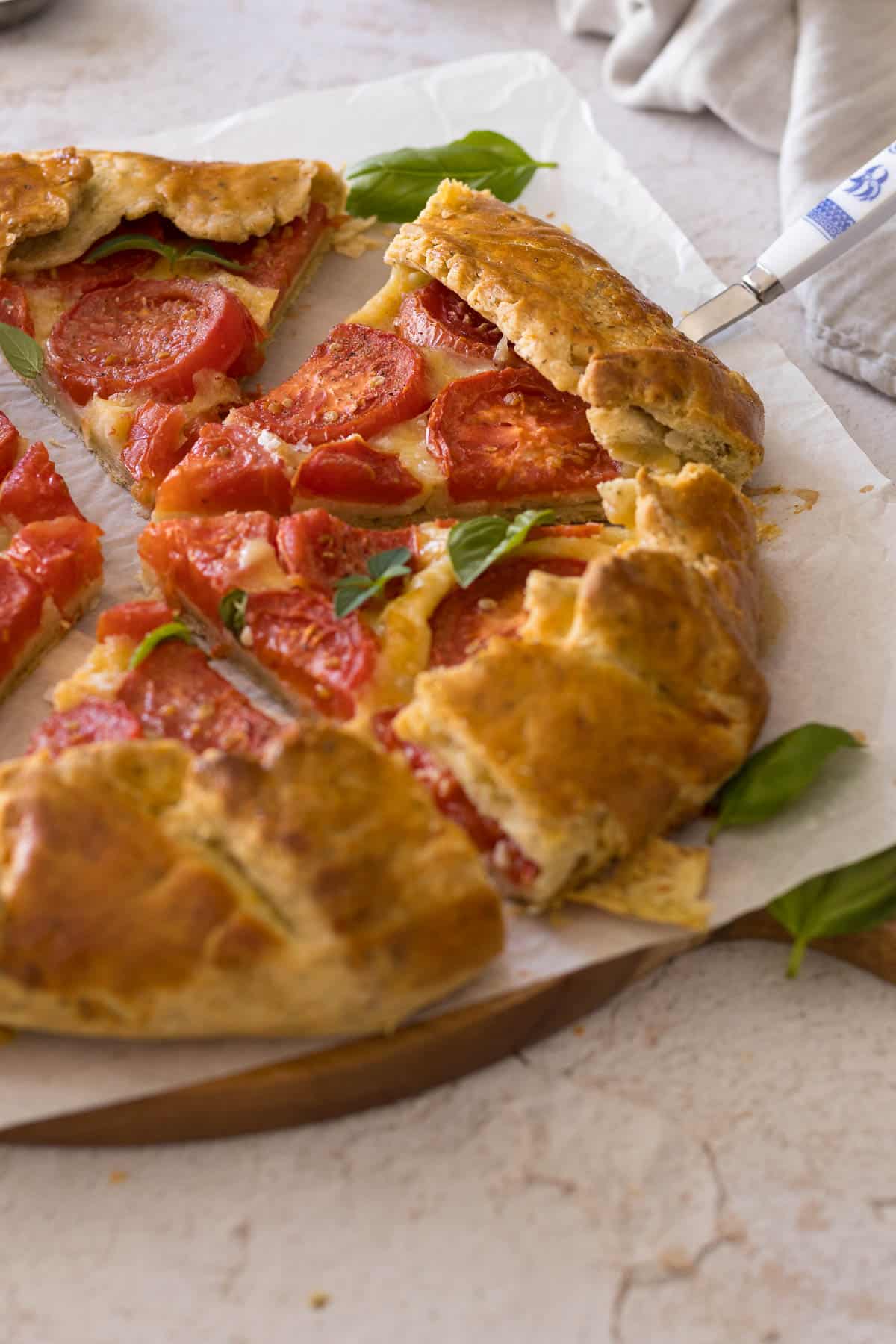 Fresh tomato galette, sliced and served on a serving board.