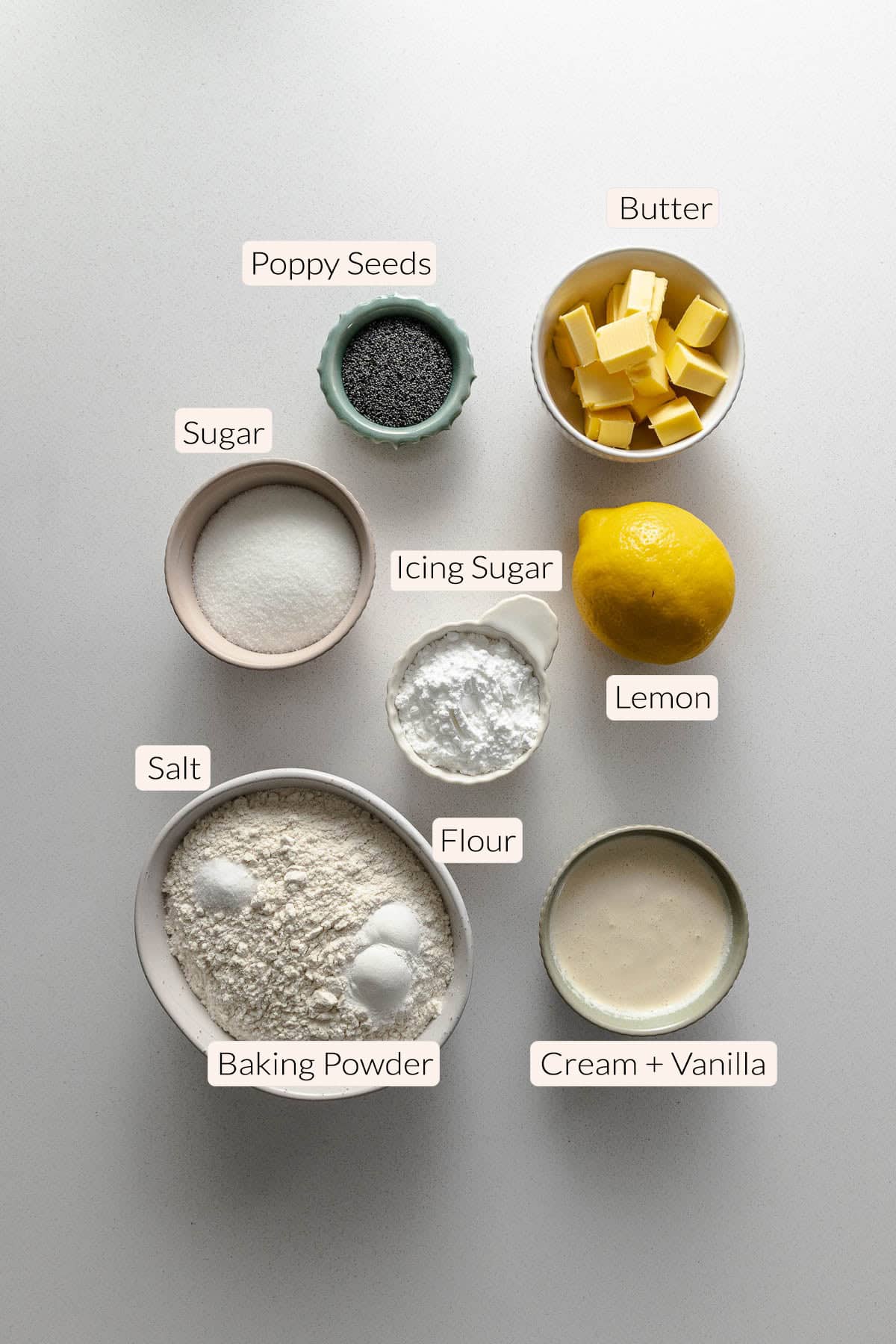 Lemon poppy seed scones ingredients - cream, vanilla, baking powder, salt, flour, lemon, icing sugar, sugar, butter, poppy seeds.