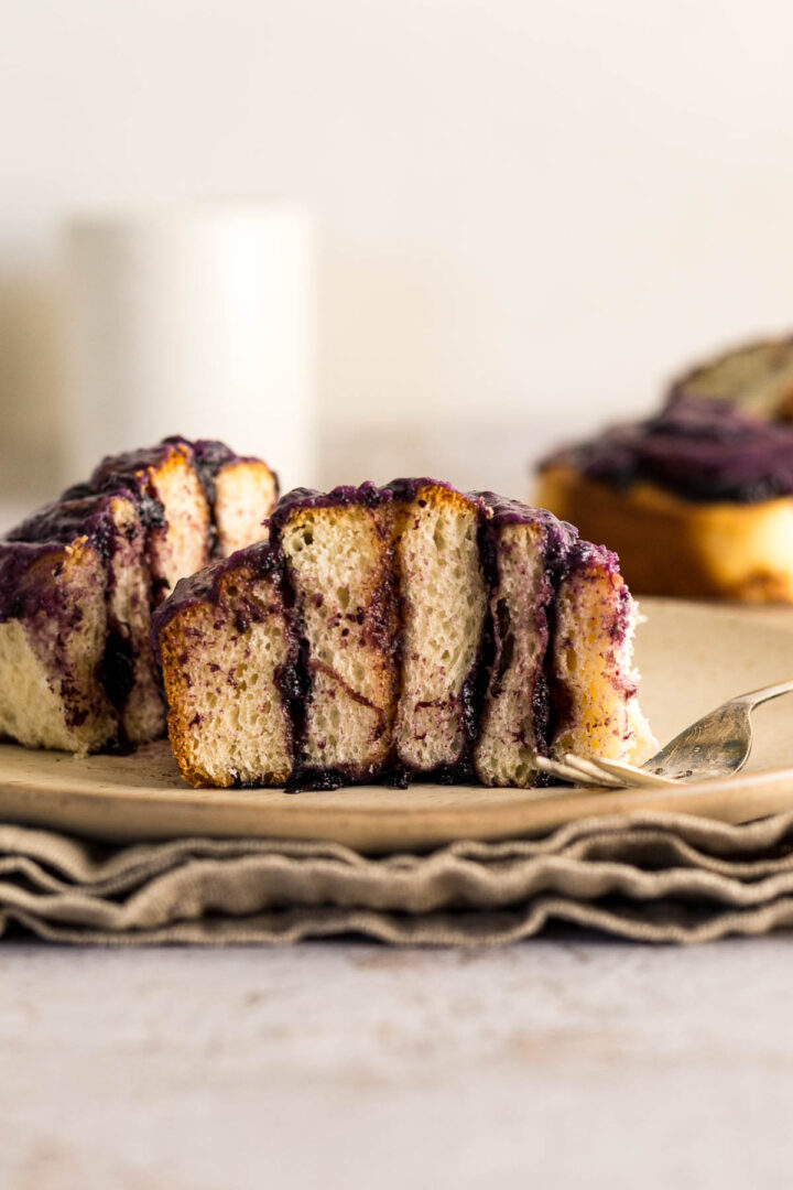 Blueberry cinnamon roll sliced in half to show the filling and crumb.