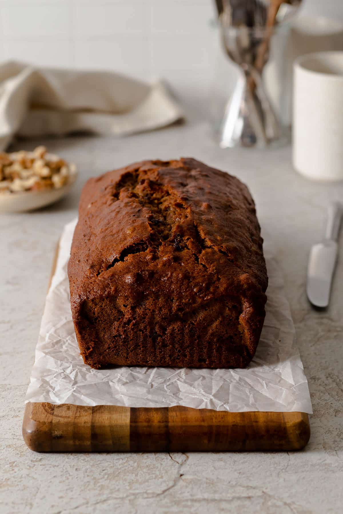 Spiced date and walnut loaf cake on a serving board.